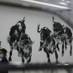 
              Workers stand near an art depicting running bulls at the newly opened Beijing Stock Exchange in Beijing Monday, Nov. 15, 2021. A stock exchange set up in the Chinese capital to serve entrepreneurs opened trading Monday with 81 companies amid a crackdown the country's tech giants that has wiped more than $1 trillion off their market value abroad. (AP Photo/Ng Han Guan)
            