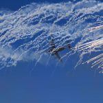 
              An Emirati military cargo jet flies through smoke after releasing chaff during a stunt at the Dubai Air Show in Dubai, United Arab Emirates, Sunday, Nov. 14, 2021. The biennial Dubai Air Show opened Sunday as commercial aviation tries to shake off the coronavirus pandemic. (AP Photo/Jon Gambrell)
            