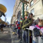 
              People watch as the Macy's Thanksgiving Day Parade passes by, Thursday, Nov. 25, 2021, in New York. The parade is returning in full, after being crimped by the coronavirus pandemic last year. (AP Photo/Seth Wenig)
            