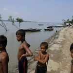 
              Boys stand by the banks in the coastal village of Gabura, which has been struck by natural disasters several times in Satkhira district, Bangladesh on Oct. 6, 2021. The effects of global warming, particularly increased cyclones, coastal and tidal flooding that bring saltwater further inland, are devastating Bangladesh and destroying the livelihoods of millions, said Mohammad Shamsuddoha, chief executive of the Center for Participatory Research Development, a non-profit. He said that projections show that around 30 million people may be displaced from the country’s coastal regions. “It’s a grave concern for a country like Bangladesh,” he said. (AP Photo/Mahmud Hossain Opu)
            