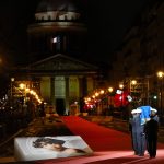 
              Pictures of Josephine Baker adorn the red carpet as the coffin with soils from the U.S., France and Monaco is carried towards the Pantheon monument in Paris, France, Tuesday, Nov. 30, 2021, where Baker is to symbolically be inducted, becoming the first Black woman to receive France's highest honor. Her body will stay in Monaco at the request of her family. (AP Photo/Christophe Ena)
            