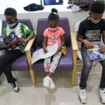 
              FILE - Siblings Amechi, 7, left, Chizara, 5, center and Kenechi Acholonu, 9, enjoy gifts from the hospital as they wait in the observation area after being inoculated with the first dose of the Pfizer COVID-19 vaccine for children 5 to 11 years at The Children's Hospital at Montefiore, Wednesday, Nov. 3, 2021, in the Bronx borough of New York. First shots are averaging about 300,000 per day. (AP Photo/Mary Altaffer, File)
            