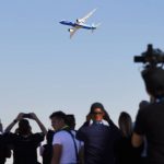 
              A crowd watches a Boeing 777X fly at the Dubai Air Show in Dubai, United Arab Emirates, Sunday, Nov. 14, 2021. The biennial Dubai Air Show opened Sunday as commercial aviation tries to shake off the coronavirus pandemic. (AP Photo/Jon Gambrell)
            