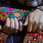 
              A Massachusetts resident identifying herself only as "Safi," who asked that her last name not be used for fear of retribution against her relatives in Afghanistan, holds a purse with traditional Afghan patterns, Tuesday, Nov. 9, 2021, during an interview with The Associated Press. Thousands of Afghans have applied for temporary admission into the U.S. for humanitarian reasons, but few have been approved since the Taliban recaptured control of their homeland. "We're worried for their lives," said Safi, whose family is sponsoring some 20 other relatives seeking humanitarian parole. (AP Photo/Steven Senne)
            