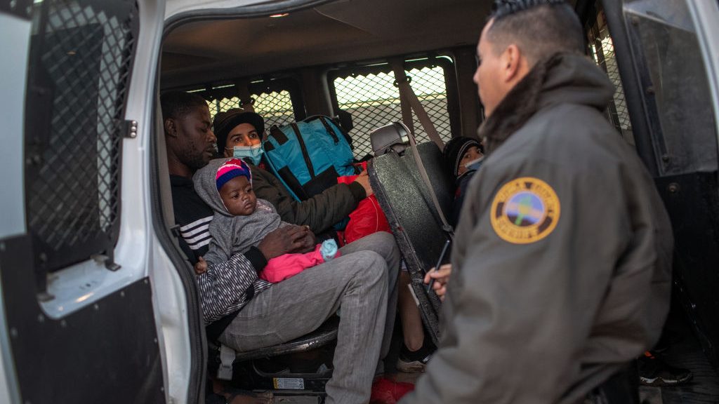 Immigrants from Haiti and Venezuela await transfer by sheriff's deputies to a U.S. Border Patrol pr...