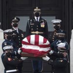 
              A military honor guard carries the flag-draped casket of former Sen. Bob Dole of Kansas, from the U.S. Capitol in Washington, Friday, Dec. 10, 2021, after lying in state. (Anna Moneymaker/Pool via AP)
            