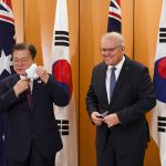
              South Korean President Moon Jae-in, left, and Australian Prime Minister Scott Morrison adjust their masks as they pose for a photo at Parliament House, Canberra, Monday, Dec. 13, 2021. Moon is on a two-day official visit to Australia. (Lukas Coch/Pool Photo via AP)
            