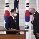 
              South Korean President Moon Jae-in, left, is invited to sign a visitor's book by Australian Prime Minister Scott Morrison at Parliament House, in Canberra, Australia, Monday, Dec. 13, 2021. Moon is on a two-day official visit to Australia. (Lukas Coch/Pool Photo via AP)
            