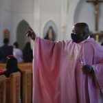 
              The Rev. Athanasius Abanulo waves to his parishioners after Mass on Sunday, Dec. 12, 2021, at Immaculate Conception Catholic Church in Wedowee, Ala. Originally from Nigeria, Abanulo is one of numerous international clergy helping ease a U.S. priest shortage by serving in Catholic dioceses across the country. (AP Photo/Jessie Wardarski)
            