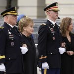 
              Chairman of the Joint Chiefs Mark Milley, left, holds the arm of former Sen. Elizabeth Dole as another member of the military holds the arm of Robin Dole, as they watch the casket of former Sen. Bob Dole, R-Kan., being carried down the East steps of Capitol Hill in Washington, Friday, Dec. 10, 2021, where he was lying in state. (AP Photo/Susan Walsh)
            