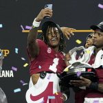
              Alabama's Jameson Williams (1) takes a selfie as Brian Robinson Jr., right, holds his trophy after the Cotton Bowl NCAA College Football Playoff semifinal game against Cincinnati , Friday, Dec. 31, 2021, in Arlington, Texas. Alabama won 27-6. (AP Photo/Jeffrey McWhorter)
            