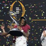 
              Alabama's Jameson Williams (1) holds up the winner's trophy as coach Nick Saban, right, watches after the Cotton Bowl NCAA College Football Playoff semifinal game against Cincinnati, Friday, Dec. 31, 2021, in Arlington, Texas. Alabama won 27-6. (AP Photo/Jeffrey McWhorter)
            
