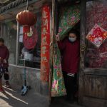 A customer wearing a mask leaves from a dumplings restaurant in Beijing, China on Dec. 21, 2021. Caseloads of omicron have remained relatively low in many countries in Asia. For now, many remain insulated from the worst, although the next few months will remain critical. (AP Photo/Ng Han Guan)