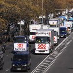 A convoy of trucks with banners reading 'SOS, Transport. We can't hold out any longer' and 'That's enough' drive slowly during a protest in the Castellana boulevard in Madrid, Spain, Wednesday, Dec. 15, 2021. Governments worldwide are facing protests, work stoppages or other political pressure to take action against soaring inflation. Spanish truck drivers ratcheted up the pressure by vowing a walkout days before Christmas and won relief on diesel prices, while Turkish citizens are protesting the government's unorthodox economic policies that have worsened surging inflation and made it a struggle to buy food and other goods. (AP Photo/Paul White)