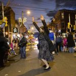 
              Rabbanit Dasi Fruchter, of the South Philadelphia Shtiebel, dances in the street during a public Hanukkah celebration and menorah lighting ceremony in South Philadelphia on Sunday, Dec. 5, 2021. Fruchter is one of about a half-dozen ordained women who serve Modern Orthodox synagogues across the U.S. and one of even fewer who serve as top spiritual leaders. (AP Photo/Ryan Collerd)
            