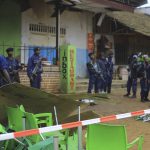 
              An area is cordoned off as police officers inspect the scene of a bomb explosion in Beni, eastern Congo Sunday Dec. 26, 2021. A bomb exploded at a restaurant Saturday as patrons gathered on Christmas Day in an eastern Congolese town where Islamic extremists are known to be active. (AP Photo/Al-hadji Kudra Maliro)
            