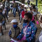 
              People line up to be vaccinated against COVID-19 in Lawley, south of Johannesburg, South Africa, Wednesday, Dec. 1, 1021. South African doctors say the rapid increase in COVID-19 cases attributed to the new omicron variant is resulting in mostly mild symptoms. (AP Photo/ Shiraaz Mohamed)
            