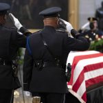 
              The honor guard salutes as the flag-draped casket of former Sen. Bob Dole, R-Kan., lies in state in the U.S. Capitol on Thursday, Dec. 9, 2021, in Washington. (AP Photo/Jose Luis Magana)
            