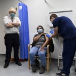 
              British Prime Minister Boris Johnson, left, watches as a patient receives a COVID-19 vaccine during his visit to the Lordship Lane Primary care center where he met staff and people receiving their booster vaccines, in London, Tuesday,  Nov. 30, 2021. (Paul Grover/Pool Photo via AP)
            