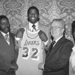 
              FILE - Earvin "Magic" Johnson, second from left, holds a Los Angeles Lakers uniform at New York's Plaza Hotel, Monday, June 26, 1979, where he was selected by the Lakers in the first round of the National Basketball Association draft. "Magic" is joined by NBA Commissioner Larry O'Brien, second from right, and by his parents. (AP Photo/Marty Lederhandler, File)
            