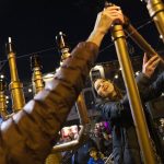 
              Rabbanit Dasi Fruchter, of the South Philadelphia Shtiebel, lights a menorah during a public Hanukkah celebration and menorah lighting ceremony in South Philadelphia on Sunday, Dec. 5, 2021. Fruchter is one of about a half-dozen ordained women who serve Modern Orthodox synagogues across the U.S. and one of even fewer who serve as top spiritual leaders. (AP Photo/Ryan Collerd)
            