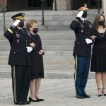 
              Former Sen. Elizabeth Dole, second from left, accompanied by Chairman of the Joint Chiefs Gen. Mark Milley, left, and Robin Dole, right, watch as the flag-draped casket of former Sen. Bob Dole of Kansas, is carried from the Washington National Cathedral following a funeral service, Friday, Dec. 10, 2021, in Washington. (AP Photo/Manuel Balce Ceneta)
            