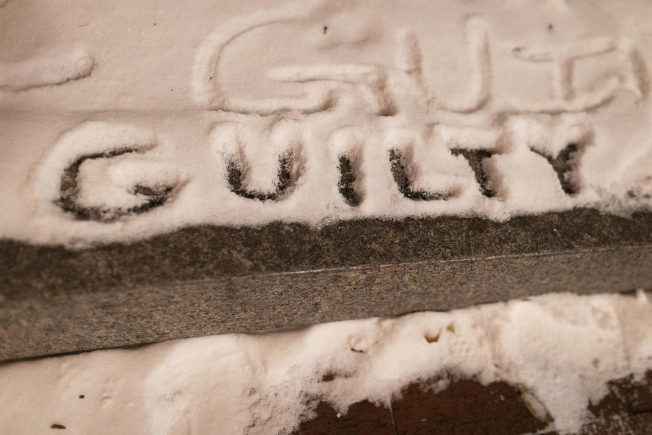 Protesters write "guilty" in the snow outside of the Hennepin County Government Center where the tr...