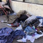 
              FILE - People sleep near discarded clothing and used needles on a street in the Tenderloin neighborhood in San Francisco, on July 25, 2019. The San Francisco Board of Supervisors will consider Thursday, Dec. 23, 2021, an emergency order to speed up the city's ability to stem the high number of overdose deaths in the notorious Tenderloin district. The emergency order is part of Mayor London Breed's plan to crack down on drug use and drug dealing in the neighborhood. (AP Photo/Janie Har, File)
            