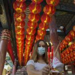 
              A woman holds joss sticks praying for good fortune on the eve of the Lunar New Year at Tai Hong Kong Shrine in Bangkok, Thailand, Monday, Jan. 31, 2022. The new year celebrations according to the lunar calendar will take place on Feb. 1. (AP Photo/Sakchai Lalit)
            