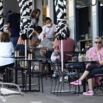 
              FILE - Customers sit outside a cafe at Bondi Beach in Sydney, Australia, Saturday, Jan. 8, 2022. The coronavirus variant has swept across Australia despite its high vaccination rate and strict border policies that kept the country largely sealed off from the world for almost two years. (AP Photo/Mark Baker, File)
            