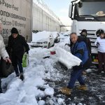 
              A track driver trapped for hours in a motorway shovel snow in Athens, on Tuesday, Jan. 25, 2022. Army and fire service teams were deployed late Monday to extract hundreds of motorists trapped for hours in snowed-in cars. A snowstorm of rare severity disrupted road and air traffic Monday in the Greek capital of Athens and neighboring Turkey's largest city of Istanbul, while most of Greece, including — unusually — several Aegean islands, and much of Turkey were blanketed by snow. (AP Photo/Michael Varaklas)
            