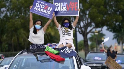FILE - Claudia Cedillos, left, waves signs with her daughter Montserrat before a campaign rally for...