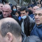 
              Serbian tennis player Novak Djokovic, center, wearing a face mask, arrives in the municipal building in Budva, Montenegro, Friday, Jan. 28, 2022. Djokovic arrived to receive a plaque declaring him an honorary citizen of the town. (AP Photo/Risto Bozovic)
            