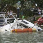 
              People look at a damaged boat in a marina at Tutukaka, New Zealand, Sunday, Jan. 16, 2022, after waves from a volcano eruption swept into the marina. An undersea volcano erupted in spectacular fashion Saturday near the Pacific nation of Tonga, sending tsunami waves crashing across the shore and people rushing to higher ground. (Tanya White/Northern Advcate/NZME via AP)
            