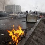 
              People walk past cars, which were burned after clashes, on a street in Almaty, Kazakhstan, Friday, Jan. 7, 2022. Kazakhstan's president authorized security forces on Friday to shoot to kill those participating in unrest, opening the door for a dramatic escalation in a crackdown on anti-government protests that have turned violent. The Central Asian nation this week experienced its worst street protests since gaining independence from the Soviet Union three decades ago, and dozens have been killed in the tumult. (AP Photo/Vasily Krestyaninov)
            