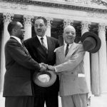 
              FILE - George E.C. Hayes, from left, Thurgood Marshall and James M. Nabrit join hands as they pose outside the Supreme Court in Washington on May 17, 1954. The three lawyers led the fight for abolition of segregation in public schools before the Supreme Court, which ruled that segregation is unconstitutional. (AP Photo, File)
            
