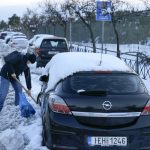 
              A man shovels to free from snow his car, in northern Athens following Tuesday's heavy snowfall, on Wednesday, Jan. 26, 2022. (AP Photo/Thanassis Stavrakis)
            