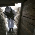 
              FILE - A serviceman walks along a trench on the territory controlled by pro-Russian militants near at frontline with Ukrainian government forces in Slavyanoserbsk, Luhansk region, eastern Ukraine, Jan. 25, 2022. Soldiers and civilians in eastern Ukraine are waiting with helpless anticipation to see if war comes. They understand that the decision will be made by people who know little about the lives of those on the eastern front lines. (AP Photo/Alexei Alexandrov, file)
            