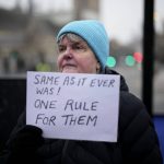
              An anti-Brexit protester holds up an anti-government placard by Parliament Square, in London, Tuesday, Jan. 25, 2022. London police said Tuesday they were investigating Downing Street lockdown parties in 2020 to determine if U.K. government officials violated coronavirus restrictions, putting further pressure on Prime Minister Boris Johnson. (AP Photo/Matt Dunham)
            