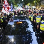 
              Fans of Serbian Novak Djokovic surround a car as it leaves the offices of lawyers following his court win ahead of the Australian Open in Melbourne, Australia, Monday, Jan. 10, 2022. An Australian judge has reinstated Djokovic's visa, which was canceled after his arrival last week because he is unvaccinated.(AP Photo/Mark Baker)
            