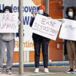 
              FILE - Women hold signs outside housing commission apartments under lockdown in Melbourne, Australia, on Monday, July 6, 2020. The coronavirus variant has swept across Australia despite its high vaccination rate and strict border policies that kept the country largely sealed off from the world for almost two years. (AP Photo/Andy Brownbill, File)
            