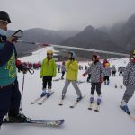 
              A ski instructor points with a pole with school children taking ski lessons at the Vanke Shijinglong Ski Resort in Yanqing on the outskirts of Beijing, China, Thursday, Dec. 23, 2021. The Beijing Winter Olympics is tapping into and encouraging growing interest among Chinese in skiing, skating, hockey and other previously unfamiliar winter sports. It's also creating new business opportunities. (AP Photo/Ng Han Guan)
            