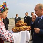 
              FILE - A woman in Ukrainian national dress welcomes Russian President Vladimir Putin with bread and salt in Zaporizhye airport, some 568 kilometers (352 miles) west of Ukraine's capital Kiev, on Oct. 6, 2002. Russia's present demands are based on Putin's purported long sense of grievance and his rejection of Ukraine and Belarus as truly separate, sovereign countries but rather as part of a Russian linguistic and Orthodox motherland. (AP Photo/Valerey Solovyev, Pool, File)
            