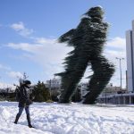 
              A woman walks past a the Runner, sculptured by Kostas Varotsos, after a snowstorm, in Athens, on Tuesday, Jan. 25, 2022. A snowstorm of rare severity disrupted road and air traffic Monday in the Greek capital of Athens and neighboring Turkey's largest city of Istanbul, while most of Greece, including — unusually — several Aegean islands, and much of Turkey were blanketed by snow. (AP Photo/Thanassis Stavrakis)
            