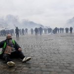 
              A man sits on the pavement as police confront protestors during a demonstration against COVID-19 measures in Brussels, Sunday, Jan. 23, 2022. Demonstrators gathered in the Belgian capital to protest what they regard as overly extreme measures by the government to fight the COVID-19 pandemic, including a vaccine pass regulating access to certain places and activities and possible compulsory vaccines. (AP Photo/Geert Vanden Wijngaert)
            