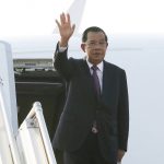 
              In this photo is provided by Cambodia's government state news agency AKP, Cambodian Prime Minister Hun Sen waves from a plane before heading to Myanmar, at Phnom Penh International Airport, in Phnom Penh, Cambodia Friday, Jan. 7, 2022. (Khem Sovannara/AKP via AP)
            