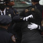 New York Police officers gather and hug outside St. Patrick's Cathedral before funeral services for Officer Jason Rivera, Friday, Jan. 28, 2022, in New York. Rivera and his partner, Officer Wilbert Mora, were fatally wounded when a gunman ambushed them in an apartment as they responded to a family dispute last week. (AP Photo/Yuki Iwamura)