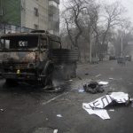 
              A body of victim covered by a banner, right, lays near to a military truck, which was burned after clashes, in Almaty, Kazakhstan, Thursday, Jan. 6, 2022. Kazakhstan's president authorized security forces on Friday to shoot to kill those participating in unrest, opening the door for a dramatic escalation in a crackdown on anti-government protests that have turned violent. The Central Asian nation this week experienced its worst street protests since gaining independence from the Soviet Union three decades ago, and dozens have been killed in the tumult. (AP Photo/Vladimir Tretyakov/NUR.KZ via AP)
            