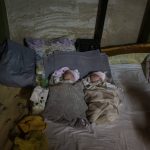 
              Newborn twin brothers sleep at a basement used as a bomb shelter at the Okhmadet children's hospital in central Kyiv, Ukraine, Monday, Feb. 28, 2022. (AP Photo/Emilio Morenatti)
            
