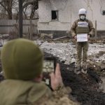 
              Members of the Joint Centre for Control and Coordination on ceasefire of the demarcation line, or JCCC, take forensic photos of a crater and damage to a house from artillery shell that landed in Vrubivka, one of the at least eight that hit the village today, according to local officials, in the Luhansk region, eastern Ukraine, Thursday, Feb. 17, 2022. U.S. President Joe Biden warned that Russia could still invade Ukraine within days and Russia expelled the No. 2 diplomat at the U.S. Embassy in Moscow, as tensions flared anew in the worst East-West standoff in decades. (AP Photo/Vadim Ghirda)
            